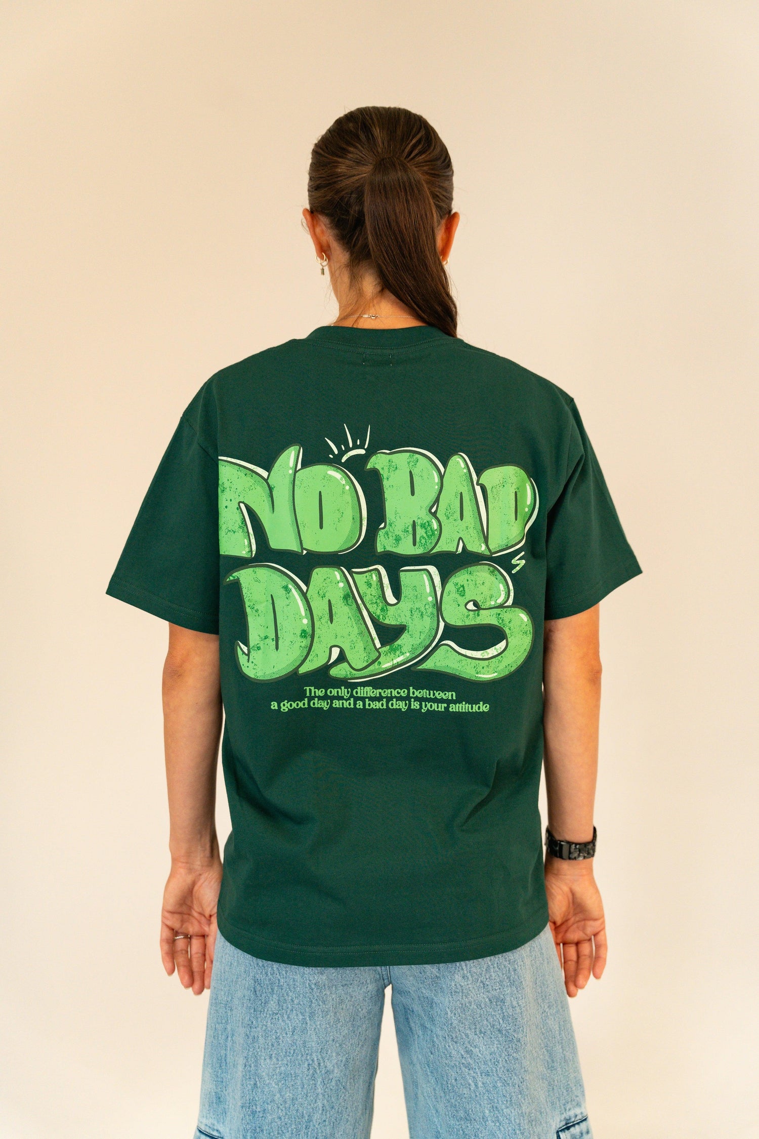 Person wearing green t-shirt with large "No Bad Days" graphic and motivational text on back