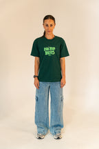 Woman wearing green graphic T-shirt with No Bad Days print, baggy cargo jeans, and sneakers