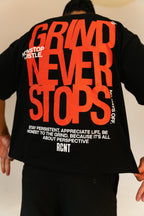 Person wearing black t-shirt with bold red text Grind Never Stops and motivational quotes on back