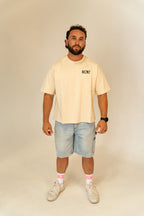 Man wearing beige RCNT t-shirt, light blue denim shorts, white sneakers, and white pink RCNT socks