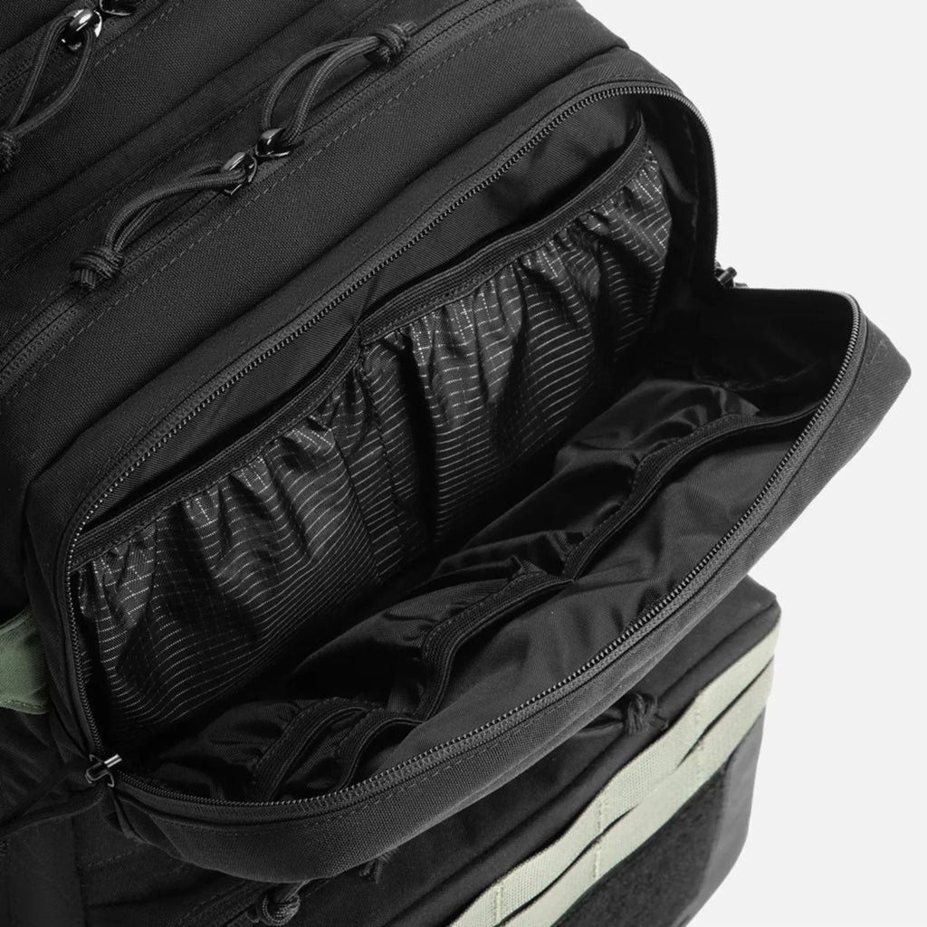 Black backpack with open zipped compartment showing interior organizer pockets and elastic sections