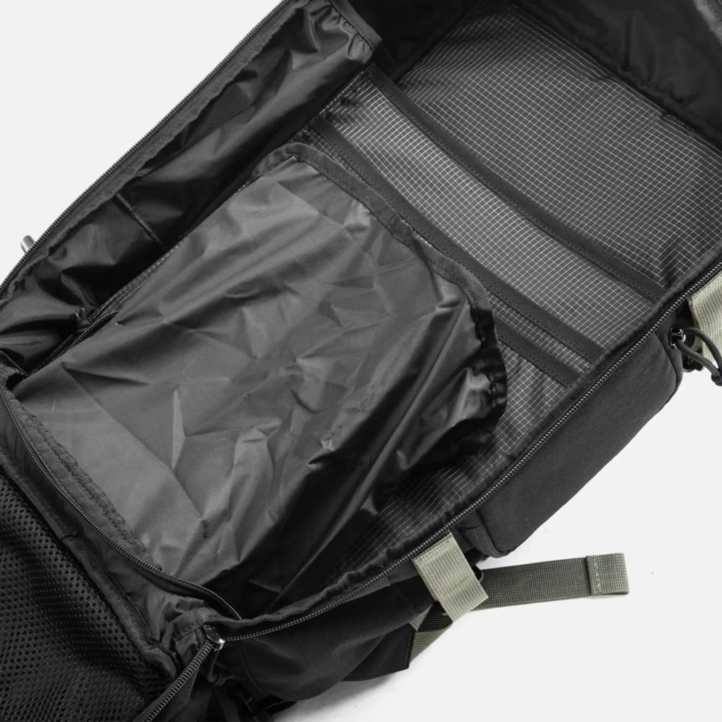 Black backpack with open compartments showing spacious interior and organizational pockets