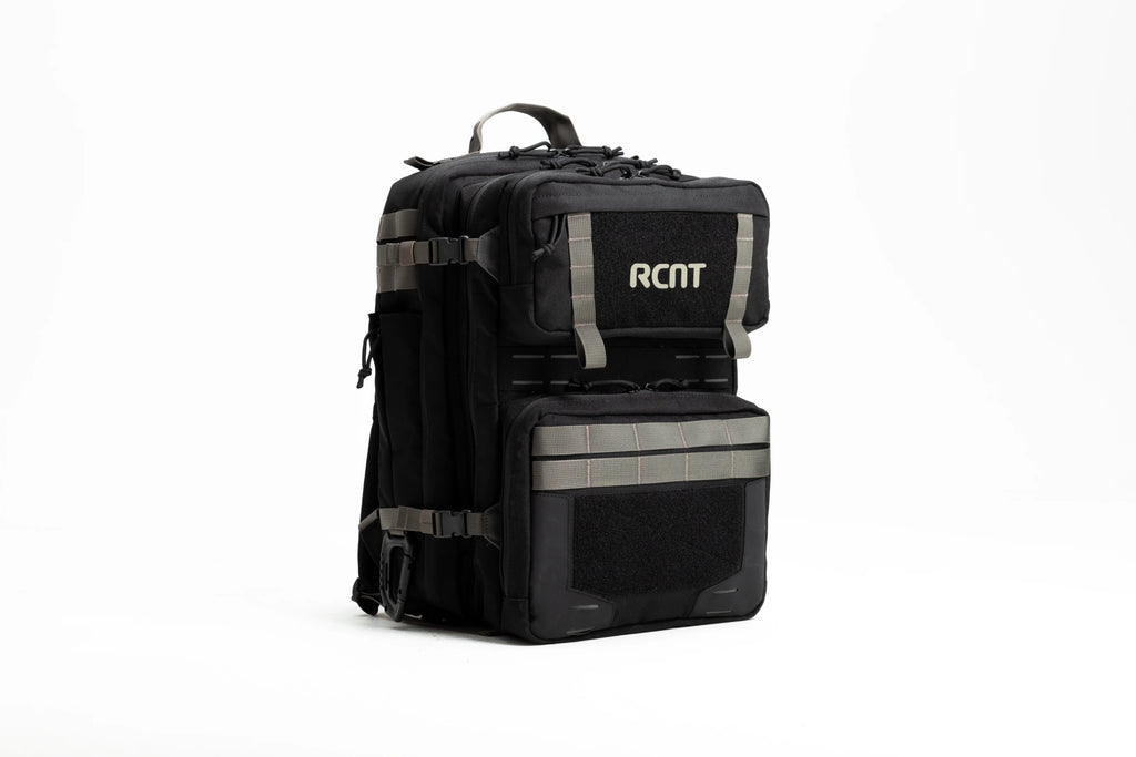 Black tactical backpack with RCNT logo, multiple compartments, and gray straps on white background