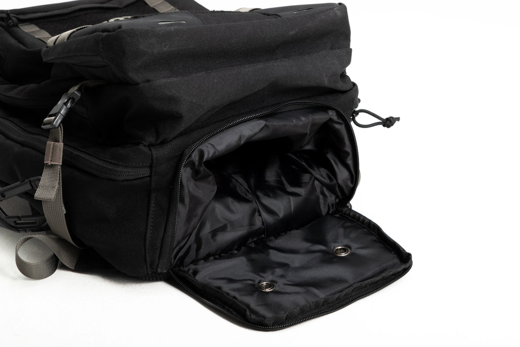 Black backpack with an open shoe compartment and gray straps on a white background