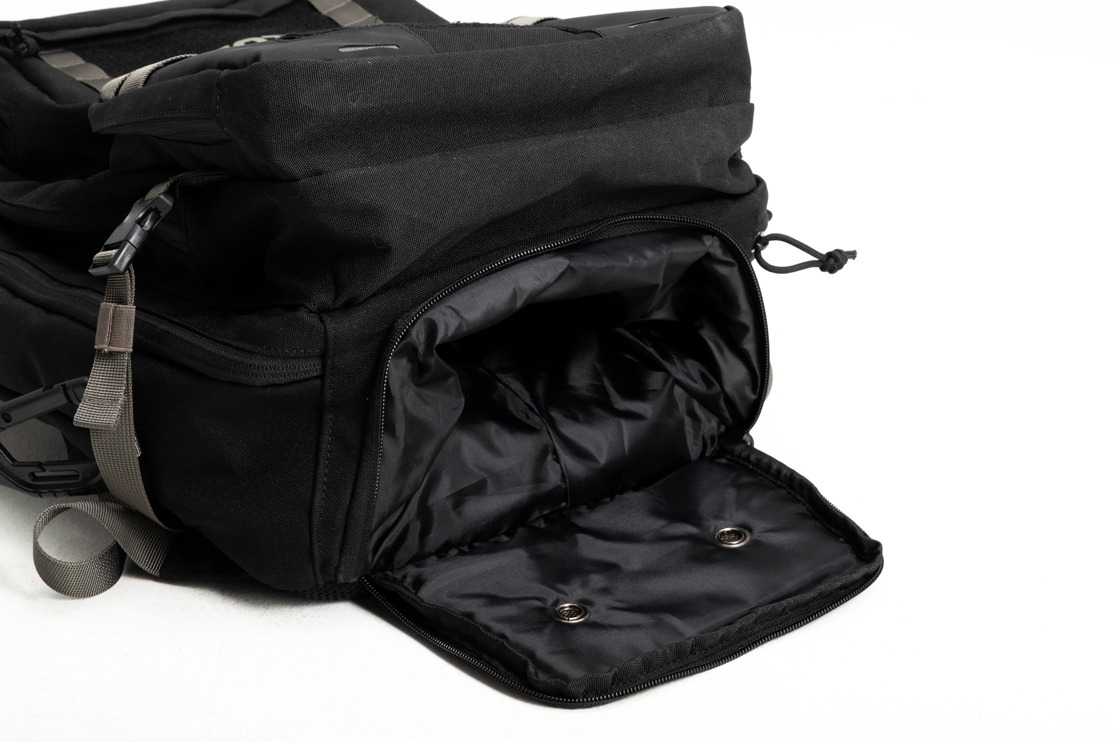Black backpack with an open shoe compartment and gray straps on a white background