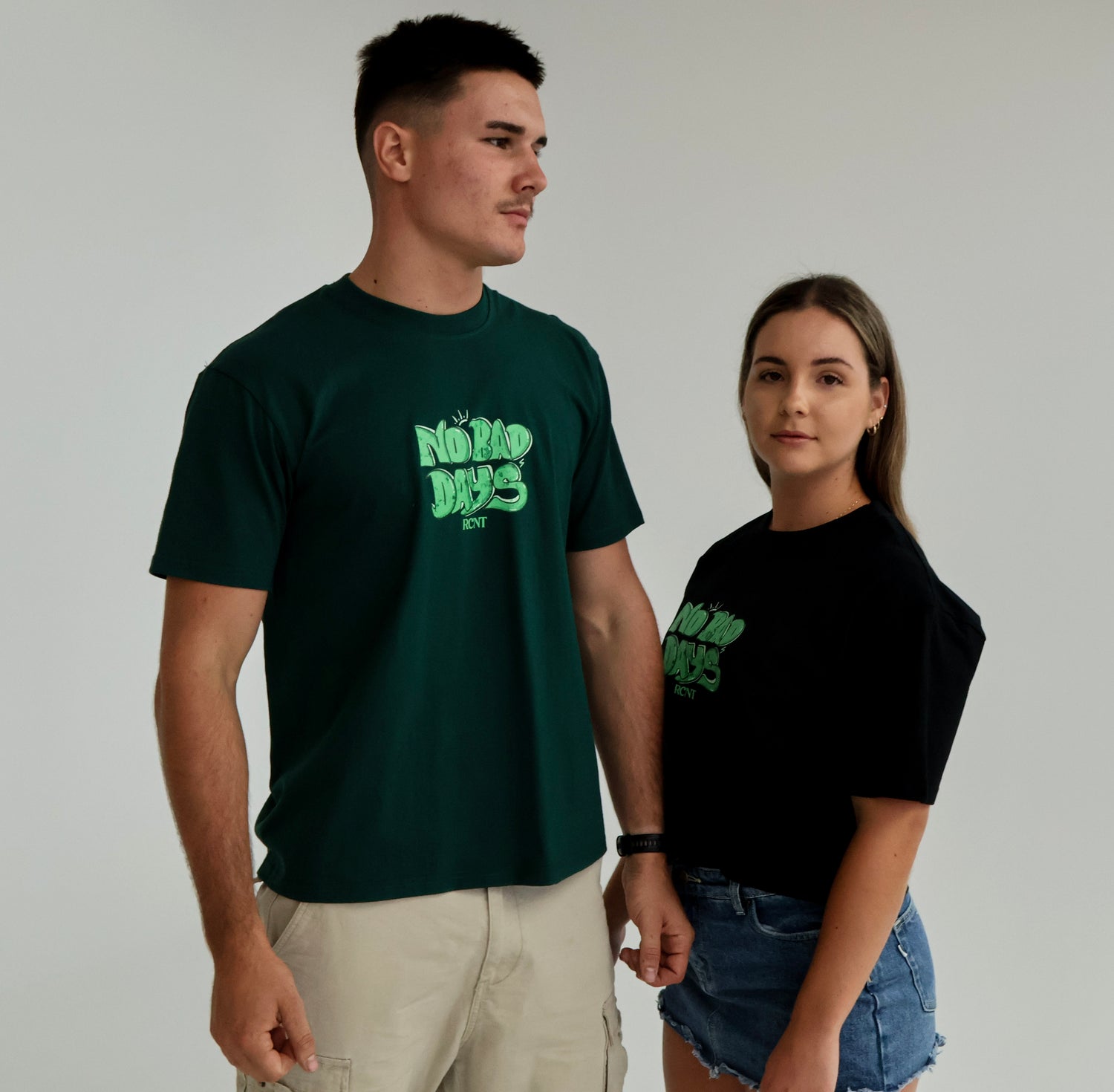 Man and woman wearing 'No Bad Days' graphic t-shirts, casual streetwear style