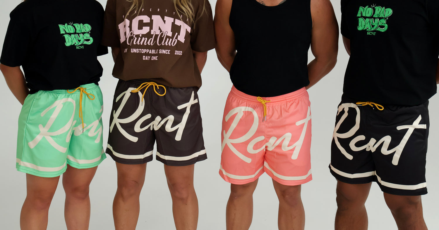 Group wearing colorful RCNT graphic shorts and t-shirts with bold lettering, back view