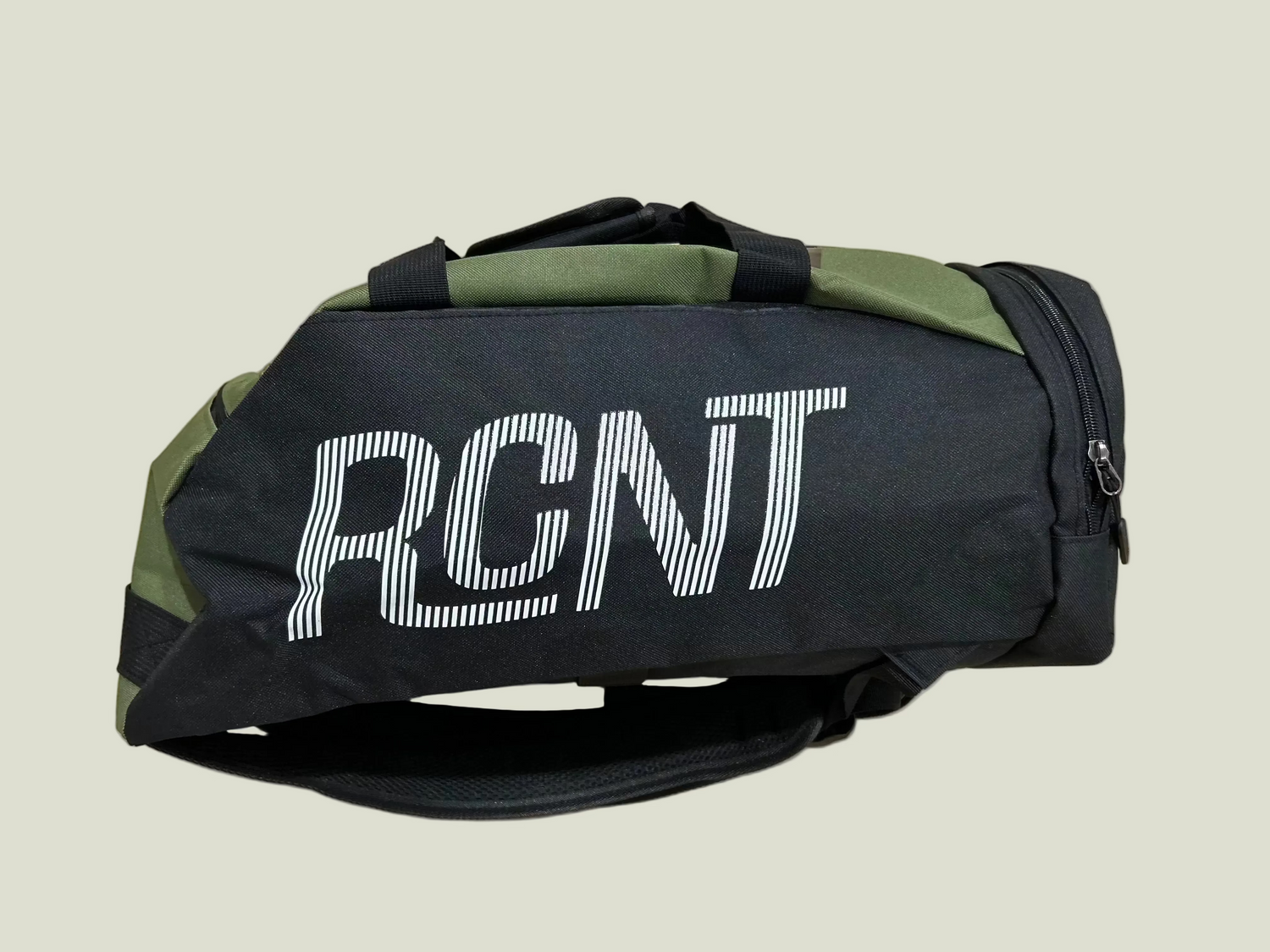 Black and green duffel bag with 'RCNT' branding on beige background.


