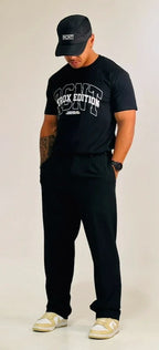 Man wearing black RCNT cap, black RCNT ProX Edition t-shirt, black pants, and beige sneakers