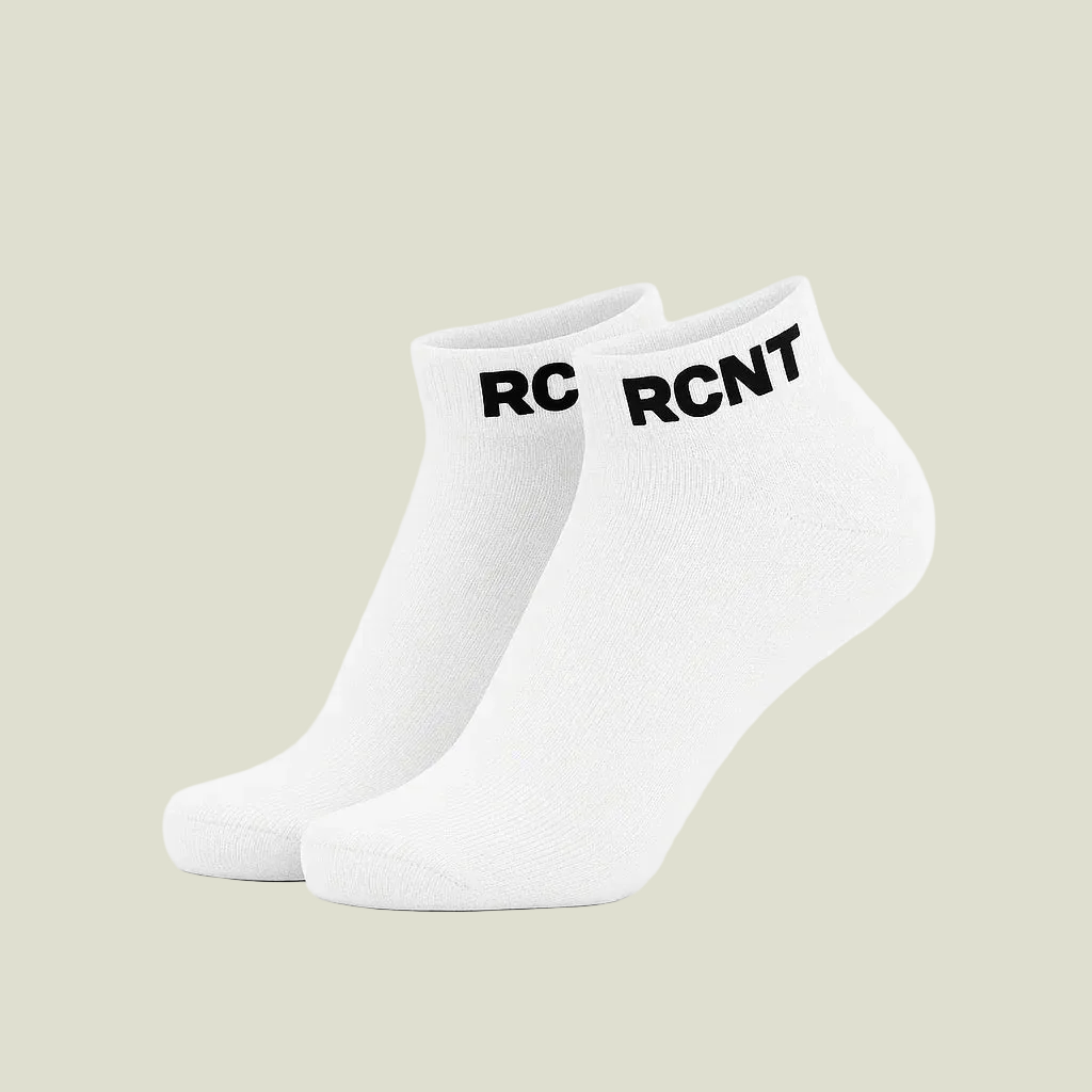 Pair of white ankle socks with black RCNT logo on cuffs on white background