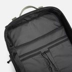 Top inside view of an empty black backpack with grid-patterned fabric and organizer pockets