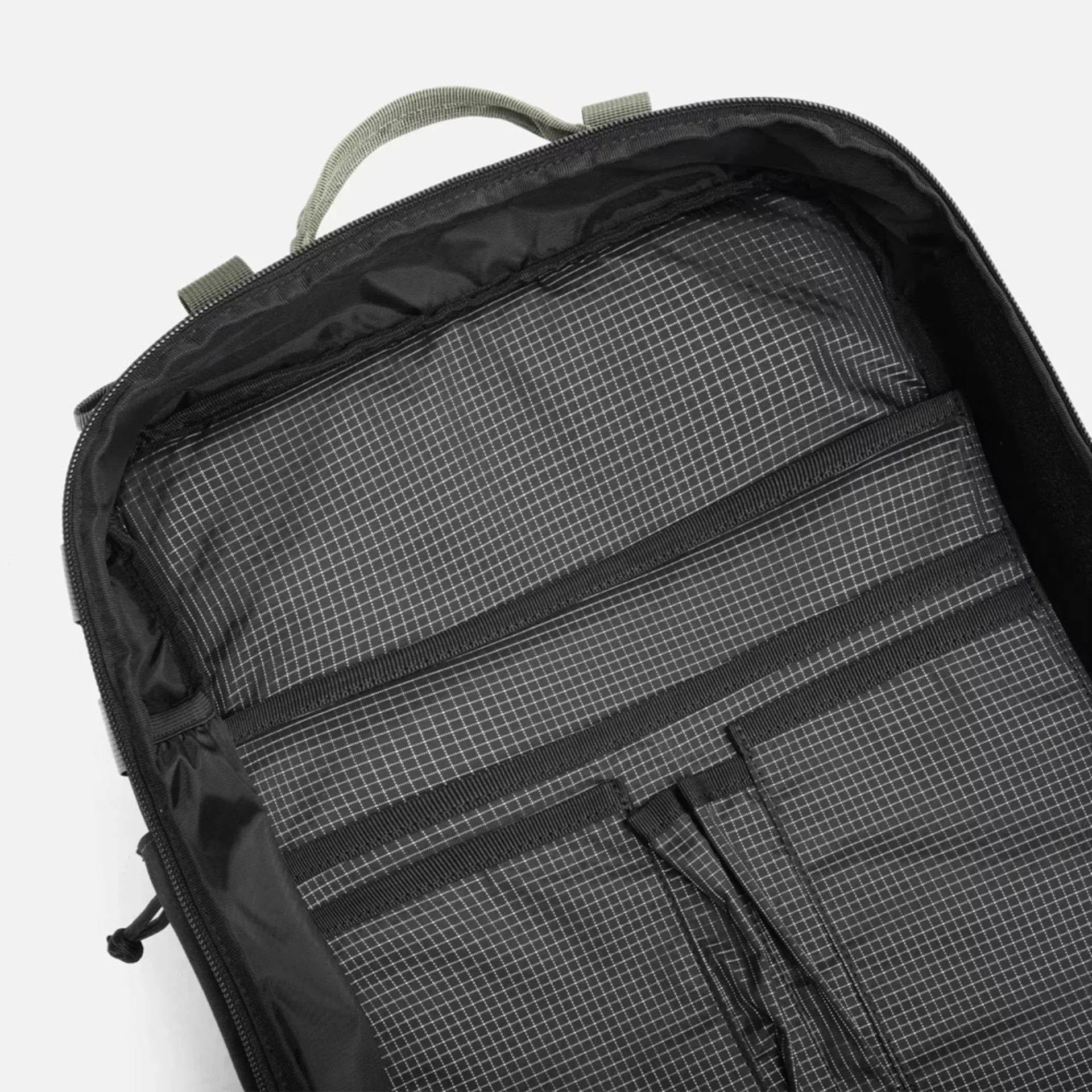 Top inside view of an empty black backpack with grid-patterned fabric and organizer pockets